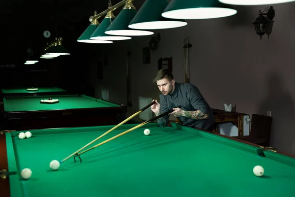 男の手とキューアームは、スヌーカーゲームをプレイしたり、緑のビリヤードテーブルの上にプールボールを撃つために目指して準備. — ストック写真