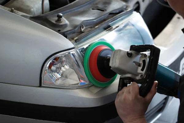 Lixar faróis de polimento em um carro em cem close-up — Fotografia de Stock