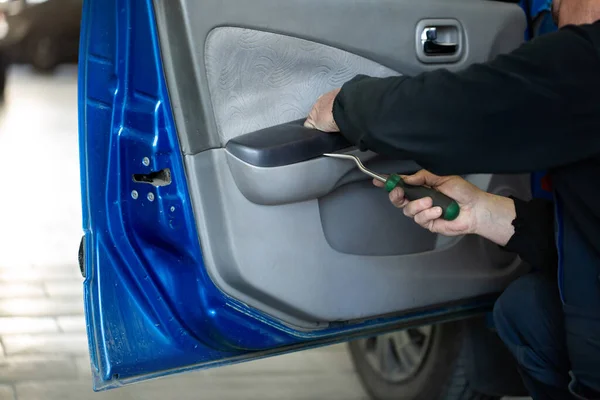 Um mecânico de automóveis repara o interior do carro — Fotografia de Stock