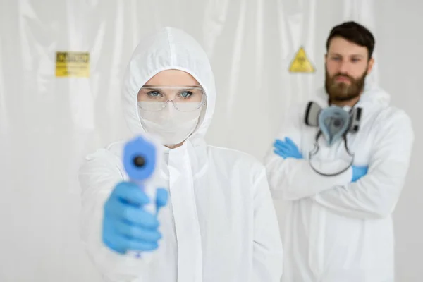 Mediziner in Schutzkleidung messen kontaktloses Fieber im Covid-19-Testzentrum während der Coronavirus-Epidemie — Stockfoto