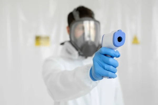 보호용 호흡기 마스크를 착용 한 의사의 근접 촬영 적외선 이마 온도계 총을 사용하여 바이러스 증상 이 유행하는 코로나 바이러스의 체온을 검사한다. — 스톡 사진