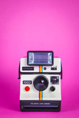 Canlı pembe arka planda Polaroid fotoğraf makinesi