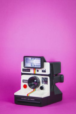 Canlı pembe arka planda Polaroid fotoğraf makinesi