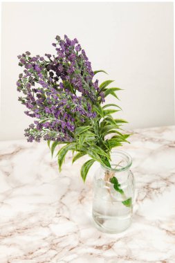 Mermer bir yüzey üzerinde cam vazoda lavanta çiçekleri