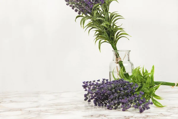 Lavender flowers in a glass vase on a marble table