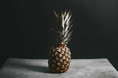 Taş bir yüzeydeki stüdyoda güzel bir ananas.