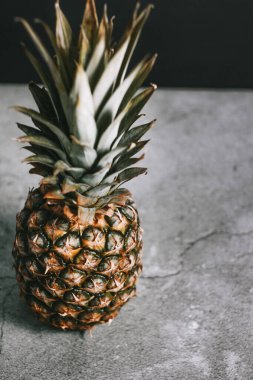 Taş bir yüzeydeki stüdyoda güzel bir ananas.