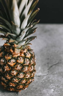 Taş bir yüzeydeki stüdyoda güzel bir ananas.