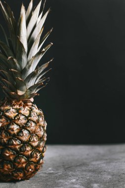 Taş bir yüzeydeki stüdyoda güzel bir ananas.