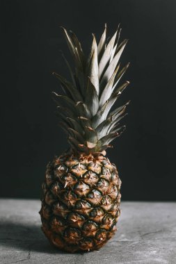 Taş bir yüzeydeki stüdyoda güzel bir ananas.