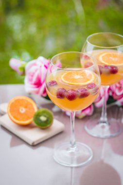 Kivili, güllü ve ahudutlu zarif şarap kadehinde portakal votkası kokteyli.