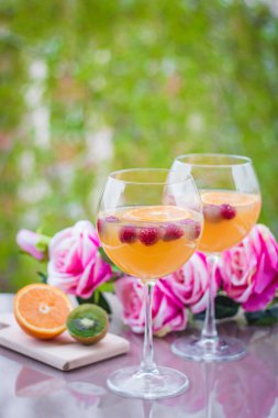 Kivili, güllü ve ahudutlu zarif şarap kadehinde portakal votkası kokteyli.