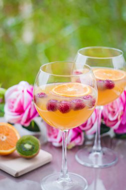 Kivili, güllü ve ahudutlu zarif şarap kadehinde portakal votkası kokteyli.