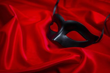 Kırmızı ipek arka planda seksi siyah maske