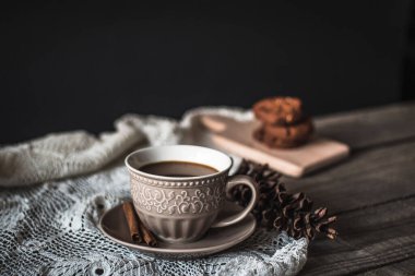 Tarçın çubuklu sıcak kahve ve ahşap arka planda kurabiyeler.