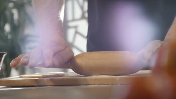 Pasta de rollos de cocinero de primer plano con rodillo en la mesa de cocina — Vídeos de Stock