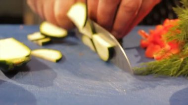 Cook elleri kesilmiş kabak bıçakla kesilerek domates öbek üzerinde tablo yönü