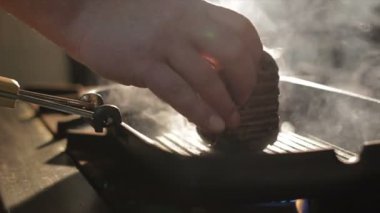 Üstünde buhar bulutlar tavada et yumru içinde closeup el turnike