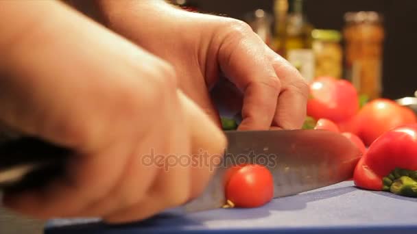 Mãos de cozinheiro corte de tomate com faca por pimentão doce na mesa — Vídeo de Stock