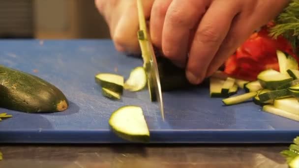 Руки макро-повара режут цуккини на тонкие ломтики на столе — стоковое видео