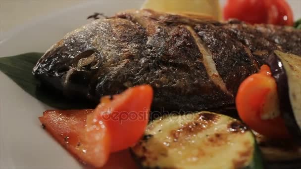 Рыба макро украшена овощными кругами на тарелке — стоковое видео