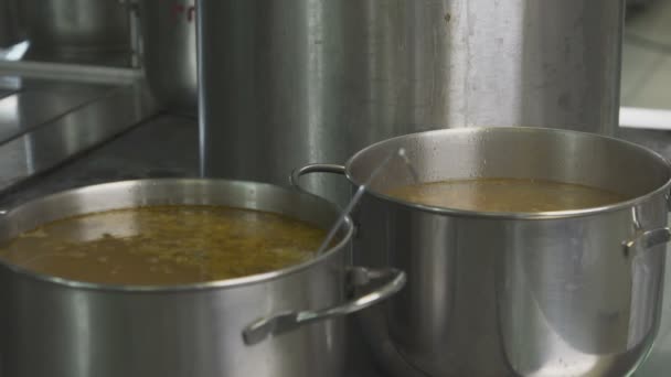 Primer plano Cook vierte sopa de una olla grande a macetas más pequeñas — Vídeo de stock