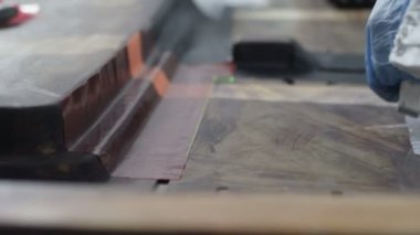 Eldiven closeup işçisi ayrıntı makineden alır.