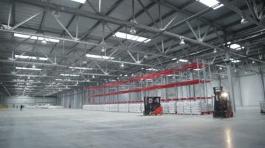 Kargo makinesi büyük dolu kutuları ve parlak lambaları olan geniş ve geniş bir ışık deposunda hareket eder.