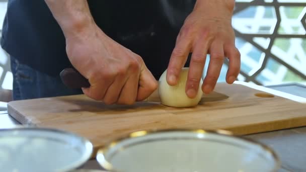 Köchin Halbiert Zwiebelschnitte Mit Messer Auf Holzbrett Schüsseln Auf Küchentisch — Stockvideo