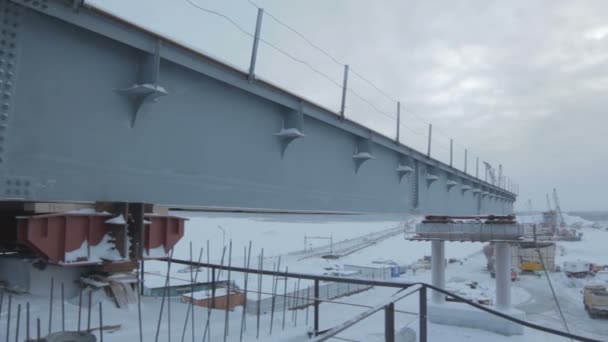建設労働者のための厳しい広大な北極の風景やロッジの雪の町の橋建設現場からの眺め — ストック動画
