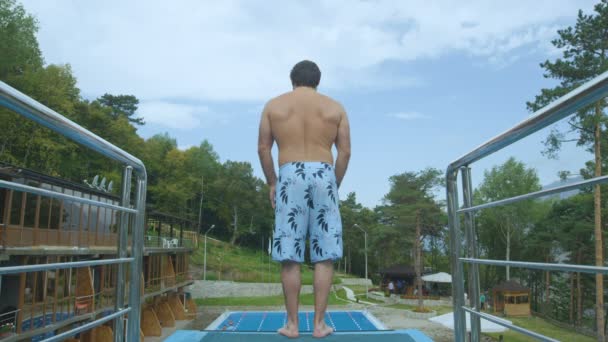 Muž, který stojí na okraji bazénu tower — Stock video