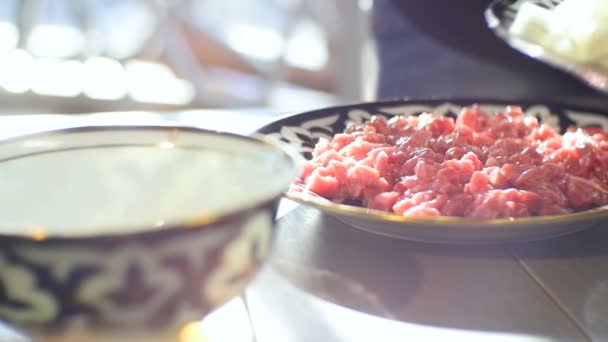 在厨房桌子上的不同碗里 把饭放在装饰好的盘子里的切好的生肉方块上 — 图库视频影像