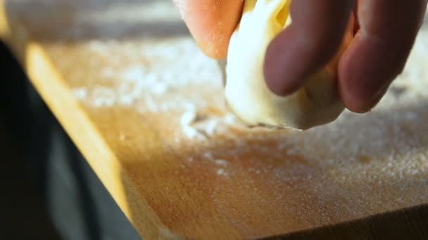 マクロ調理の手はキッチンで明るい日差しビームで小麦粉で覆われた板の上にタタールパテMantyを置きます — ストック動画