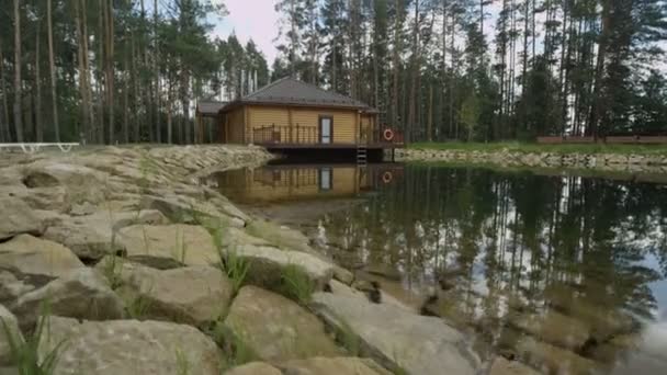 Wooden cottage on bank of rocky lake — Stock Footage Wooden cottage on bank of rocky lake Royalty Free Stock Footage