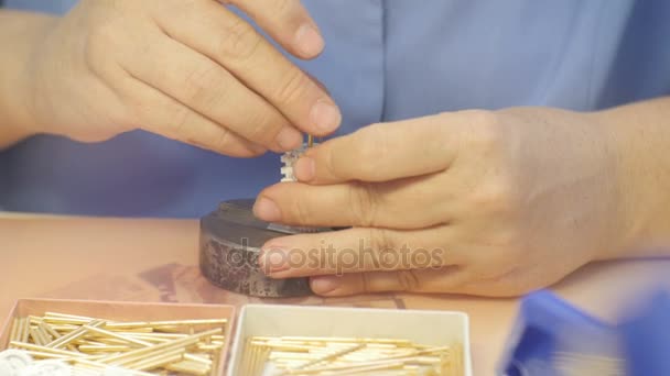 Работник кладет детали в металлические шпильки — стоковое видео