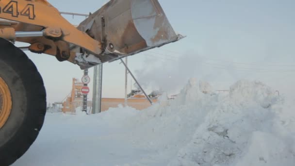 Ковша екскаватора розливу снігу на узбіччі дороги — стокове відео