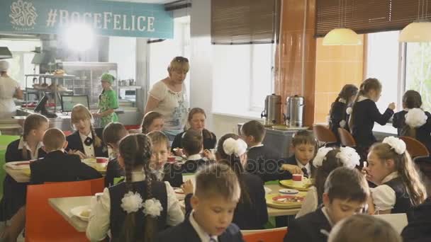 Leraar wandelen tussen tabellen op school kantine — Stockvideo