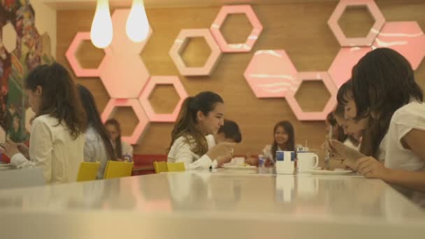 Школярки, сидячи за столом довгі білі — стокове відео