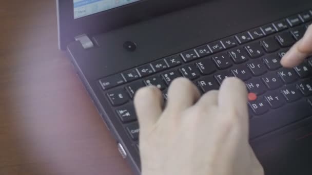 Mitarbeiter arbeitet an dunkelgrauem Laptop — Stockvideo