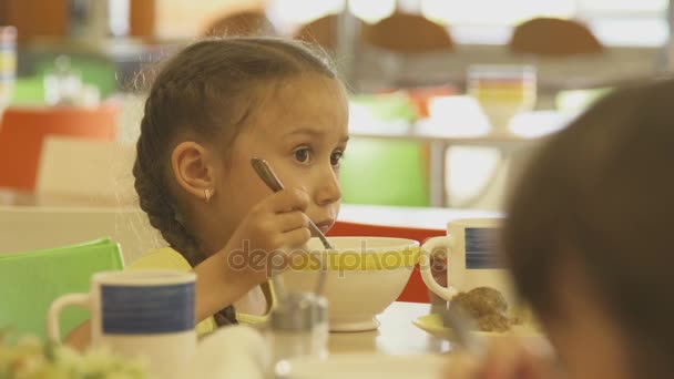 Mädchen isst Suppe in Schulkantine — Stockvideo