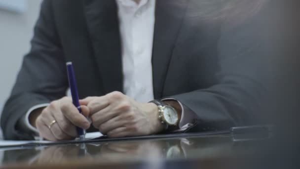 Hombre de traje sentado en la mesa brillante — Vídeos de Stock