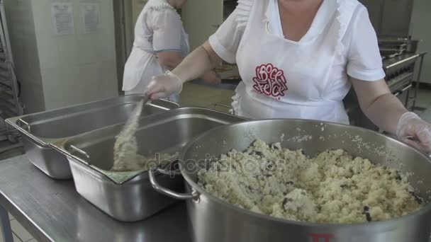 Cook putting with ladle pilaf to trays — Stock Video