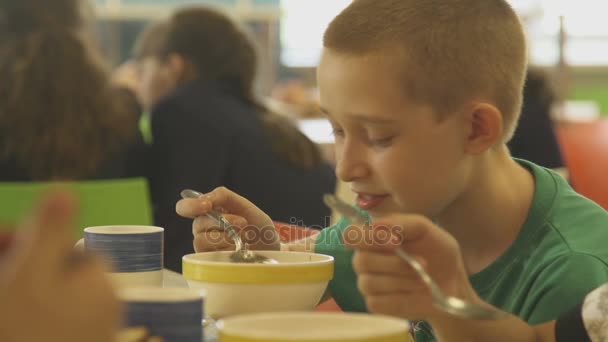 Pojken äter soppa i skolmatsalen — Stockvideo
