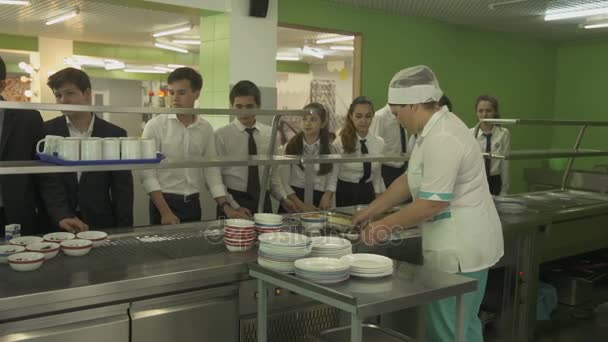 Barmeisje voedsel te geven aan leerlingen in de kantine — Stockvideo