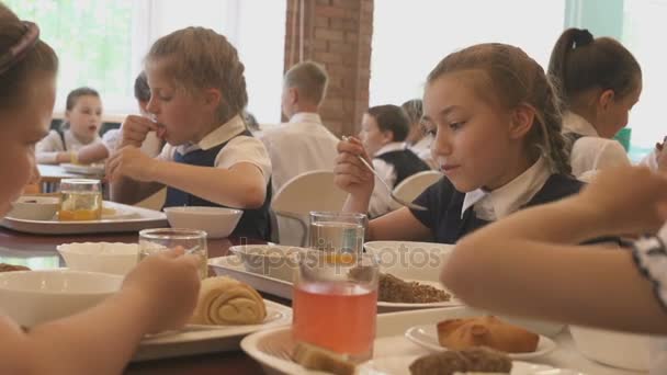 Skolflickor som äter middag på skolmatsalen — Stockvideo