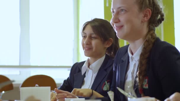 Écolière parlant avec des amis à la cafétéria de l'école — Video