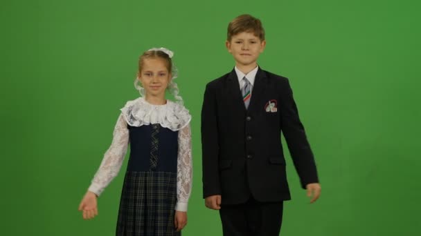 Schoolboy and schoolgirl in uniform waving hands — Stock Video