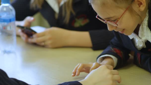 Écolière jouer sur smartphone avec un ami de l'école — Video