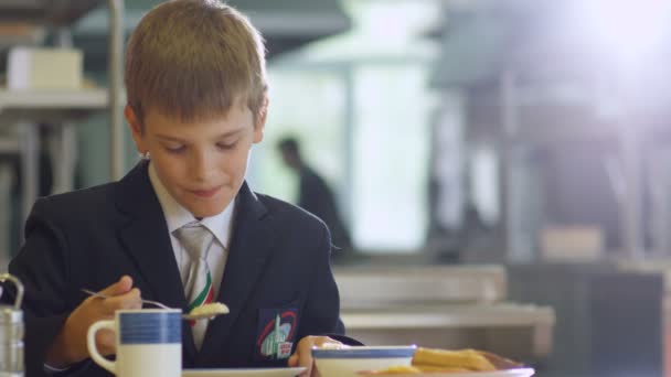 Écolier manger du porridge à la cafétéria scolaire — Video
