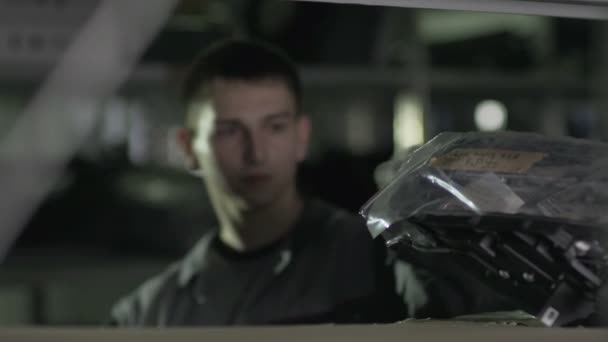 Работник принимает детали в целлофане — стоковое видео